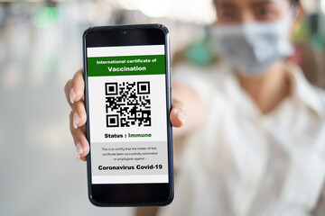 Traveler shows health passport of vaccination certification on phone at airport, to certicy that have been vaccinated of coronavirus covid-19