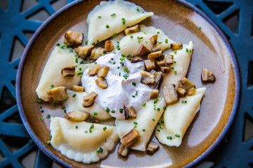 Traditional Slovak food - Bryndzove pyrohy with bacon on plate. Sheep cheese dumplings with bacon and sour cream The food in the restaurant. Food styling and restaurant meal serving.