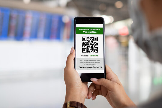 Traveler shows health passport of vaccination certification on phone at airport, to certicy that have been vaccinated of coronavirus covid-19