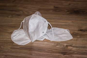 White respiratory mask N95 FFP2 on a wooden background close-up. Coronavirus Medical Protection Concept. Protective masks. Protection against pollution, virus, flu and corona virus.