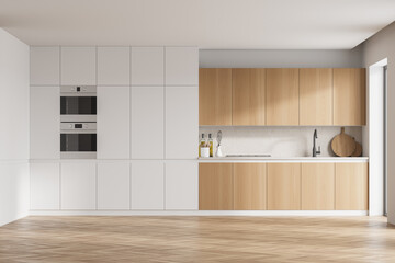 Modern kitchen interior with white walls, modern countertops with a built in sink and a cooker.