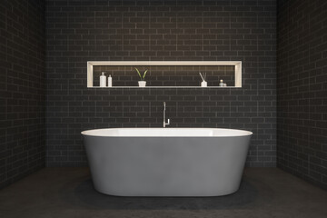 Grey bathtub and brick wall, shelf with gels and plant, dark marble floor