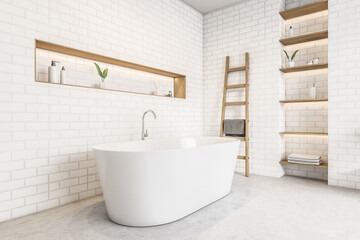 White bathtub and brick wall, shelves with gels and plants, marble floor