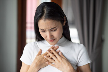 sick asian woman with indigestion problem, acid reflux or gerd symptoms; woman health care, body...