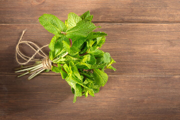 Fresh green mint leaves close-up on a wooden dark background. Mentha piperita plant.