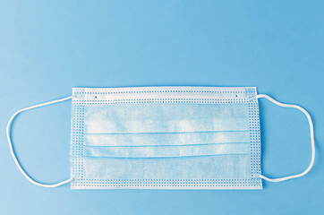 Medical mask on a blue background, surgical face mask protection against COVID-19 virus
