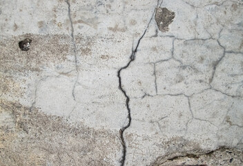 Cracks and scuffs on the concrete slab. The texture of the destruction and old age of building material.