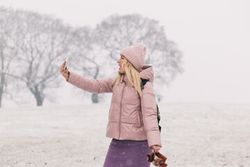 Fototapeta na wymiar woman in a powder jacket makes a selfie, background winter