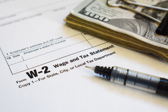 W-2 Employee Internal Revenue Service ( IRS) Tax Form Close Up With Money And Fine Point Pen 