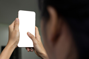 Close-up of hand held with smart phone white screen on sofa in the living room. Concept of...