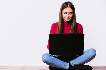 Young creative woman sitting on the floor with laptop, computer pc. Casual beauty female blogger. Video live streaming at home. Business online influencer on social media concept.