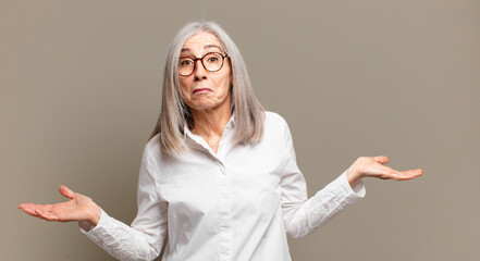 senior woman feeling puzzled and confused, unsure about the correct answer or decision, trying to...