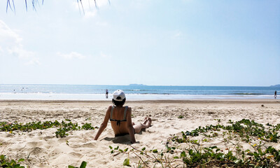 Girl sitting on the beach and looking at the sea