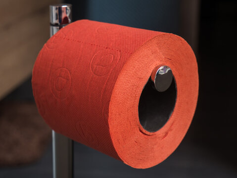 Close-up image of a roll of orange toilet paper