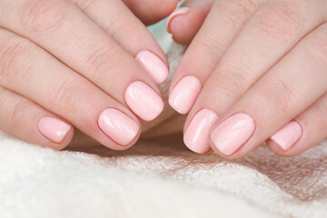 female hands with beautiful manicure and soft pink varnish on the nails..