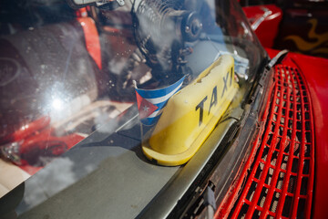 Retro car as a taxi in Cuba. Car in Cuba. Traveling by car in Cuba. The flag of Cuba next to a taxi 