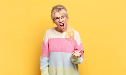 blonde woman looking angry, annoyed and frustrated screaming wtf or what’s wrong with you