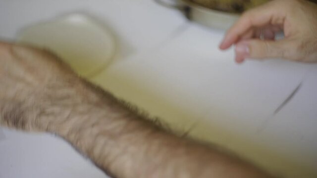 Close up of male hands preparing an argentinean empanada over a white table. Putting the filling and closing it with a home made traditional repulgue.