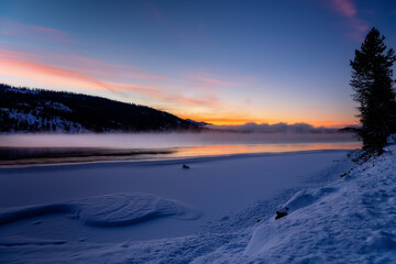 Obraz premium Beautiful sunrise over a winter frozen lake