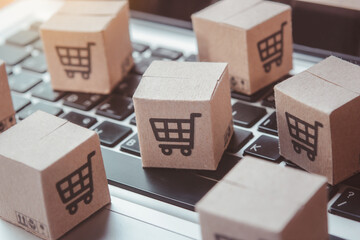 Shopping online. Cardboard box with a shopping cart logo on laptop keyboard. Shopping service on The online web. offers home delivery