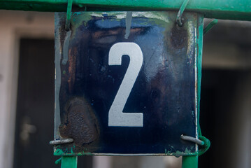 Weathered grunge square metal enamelled plate of number of street address with number 2
