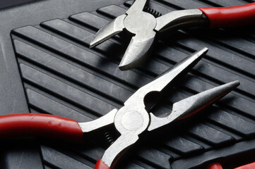 small pliers and pliers lie on a closed toolbox. view from above.