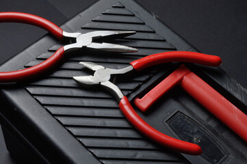 small pliers and pliers lie on a closed toolbox. view from above.