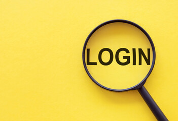 The word LOGIN is written on a magnifying glass on a yellow background.