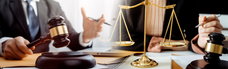 Justice and law concept.Male judge in a courtroom with the gavel, working with, computer and docking keyboard, eyeglasses, on table in morning light