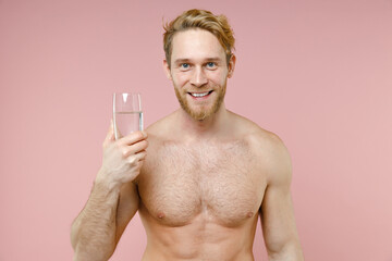 Smiling bearded naked young man 20s perfect skin hold drinking clear fresh pure water from glass...