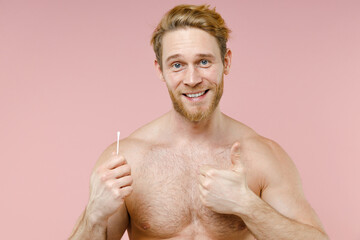 Smiling bearded naked young man 20s perfect skin hold cotton swab stick for ear cleaning showing...