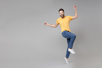 Full length of young bearded attractive smiling man 20s in casual yellow basic t-shirt with...