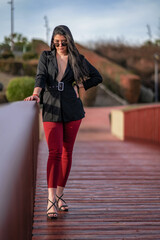 Mujer bella paseando al aire libre por un parque, desfile de moda