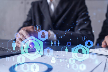 Two HR specialists man and woman analyzing the market of alumni to boost the intern program at international consulting company. Hiring new talented officers. Social media hologram icons.