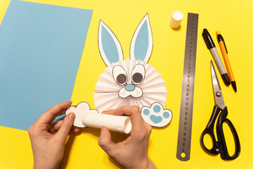 How to make a paper rabbit, bunny for Easter greetings. DIY children's art project. DIY concept. Step 11. Glue the ears, nose and paws to the body