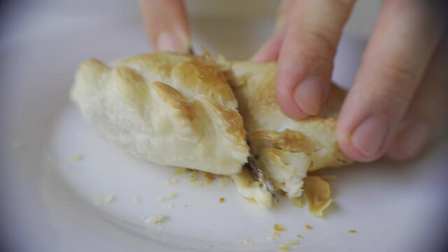 Close up of a knife cutting a recently baked warm empanada. Argentina