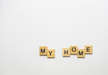 Text my home lined with wooden cubes on white background.