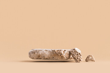 Floating stone podium for products, cosmetics, jewelry mock up on beige background.