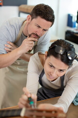 Fototapeta premium luthier works on new guitar with precision and care