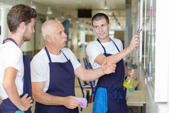 portrait of senior janitor and colleagues at work