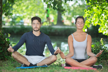 Naklejka na ściany i meble couple doing yoga in a park