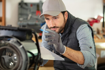 Fototapeta na wymiar man with clipboard inspecting an electrical appliance