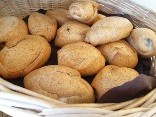 Small rolls of wholemeal bread in a basket. Macro bread.