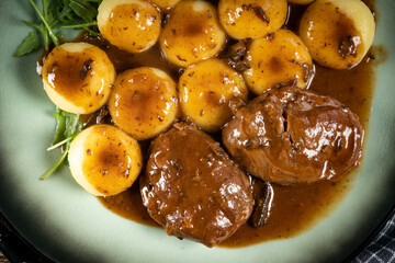 Traditional German braised pork cheeks in brown sauce.