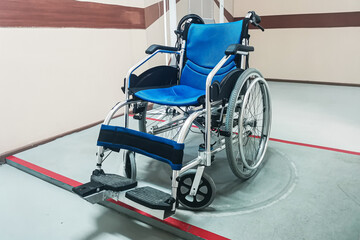 Manual foldable wheelchair with chrome plated steel frame, fixed footrest and blue seat cushions...