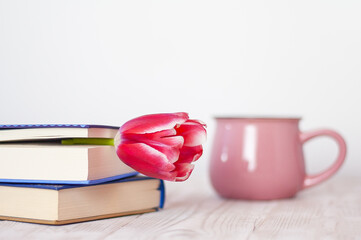 tulip bookmark in a book on the table and a cup