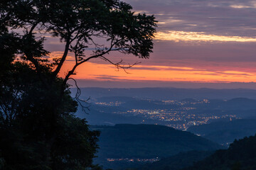 Sunset with trees, forest, valley and city lights