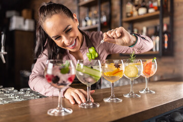 Bartender makes summer refreshing gin tonic cocktails on a bar - obrazy, fototapety, plakaty