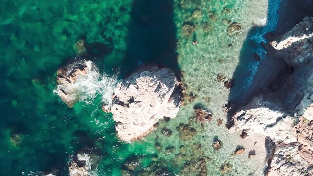 Beautiful rocks on the beach, Elba Island overhead view, Italy. Slow motion