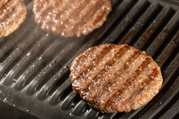 Fresh beef cutlets on a grill. Cooking a burger at home. Delicious and healthy food concept.